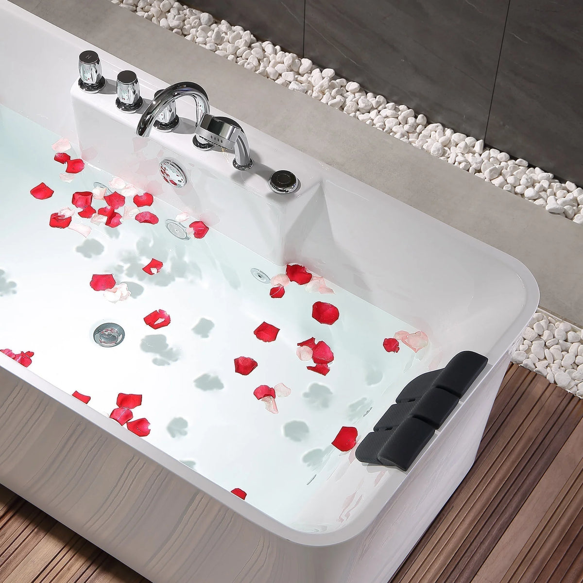 White acrylic whirlpool bathtub with aqua water, black headrest, and chrome controls.