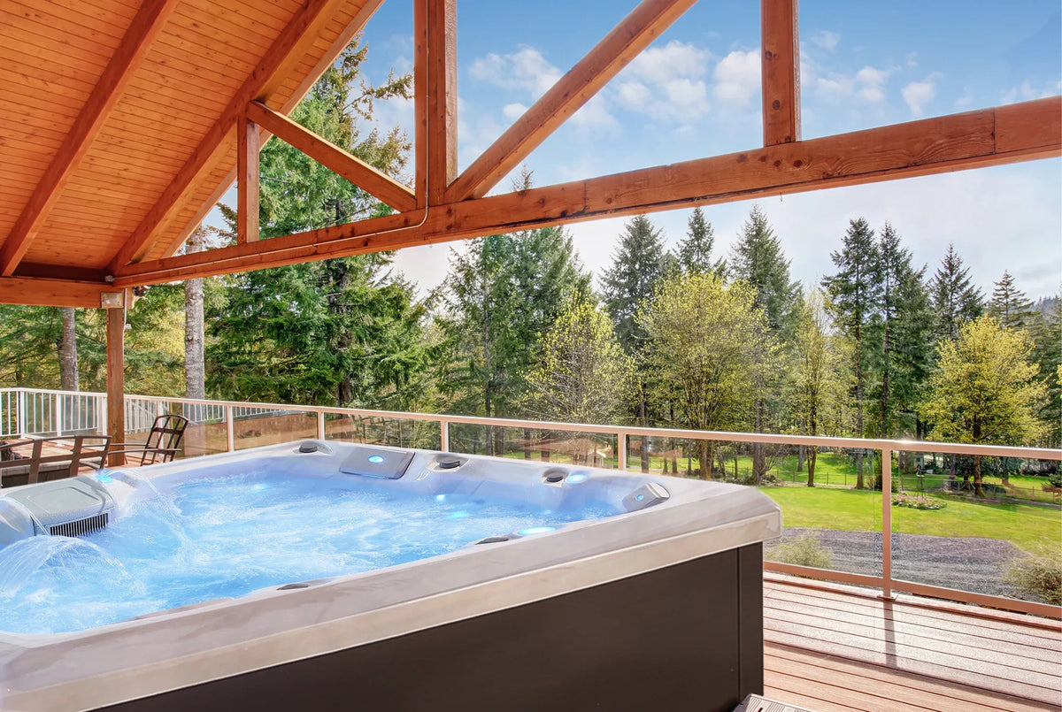 Square outdoor hot tub with gray cabinet and open spa cover, on a wooden deck