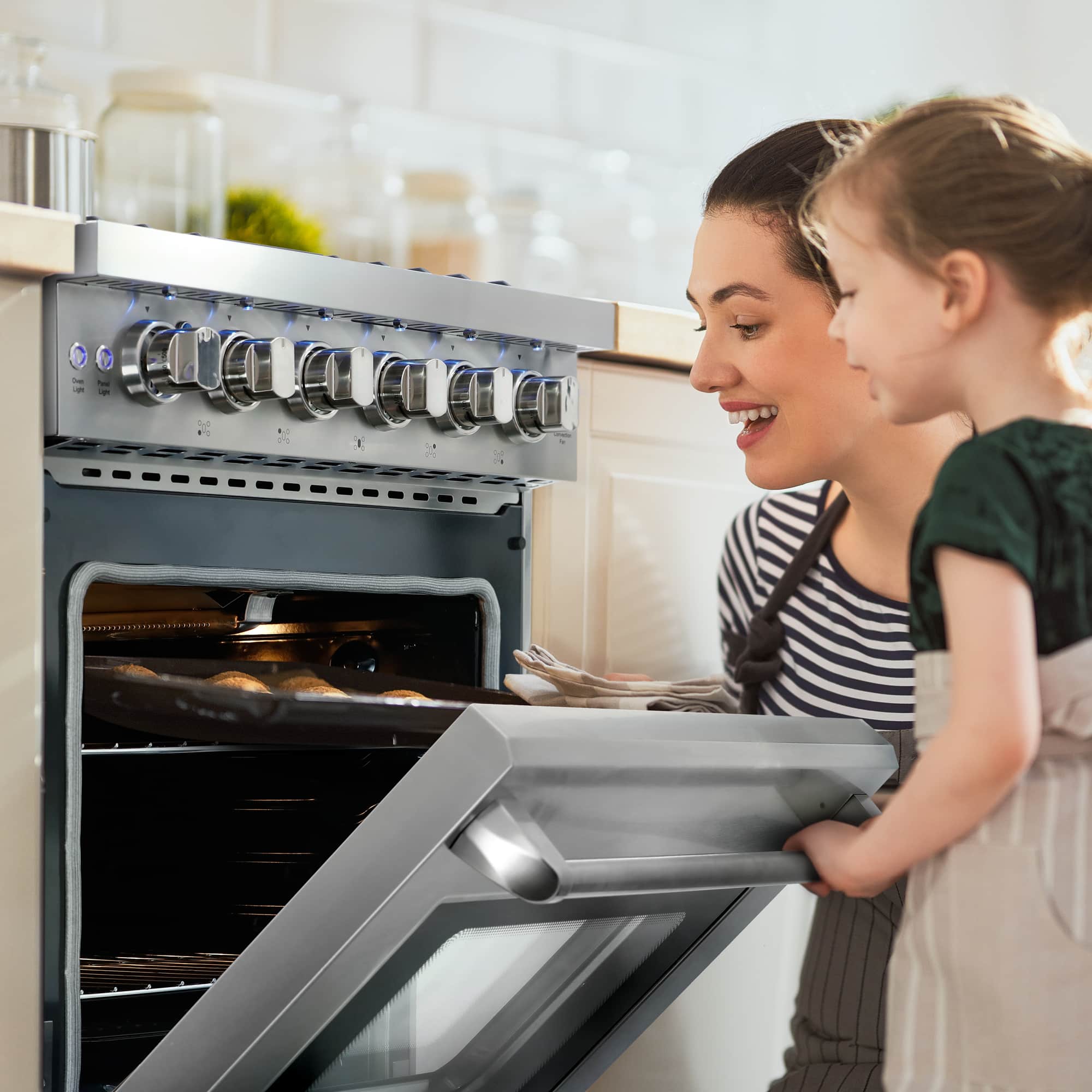 Stainless steel gas range, open oven door, front burner controls and cooktop grates