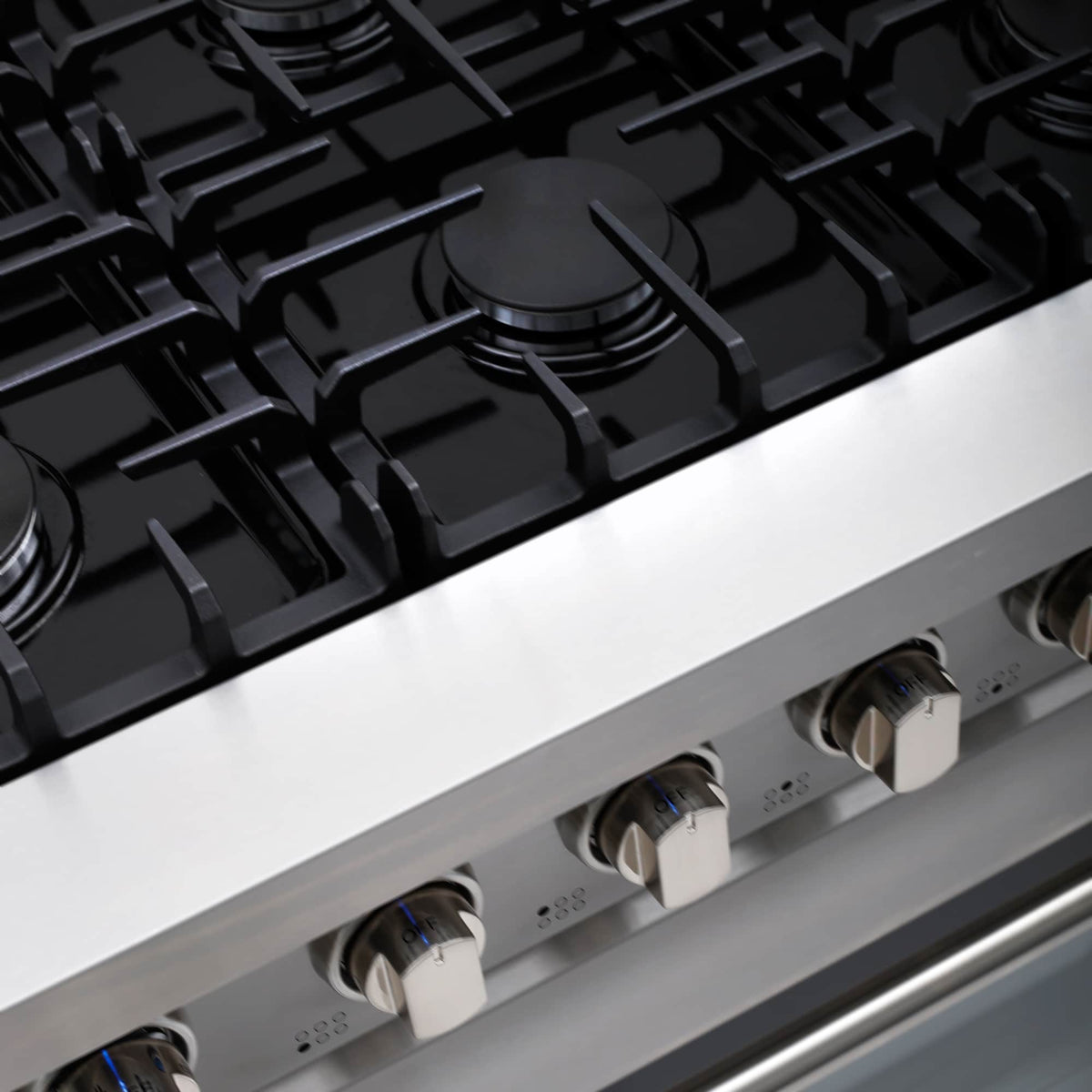Black gas cooktop with grates and front burner controls on stainless range