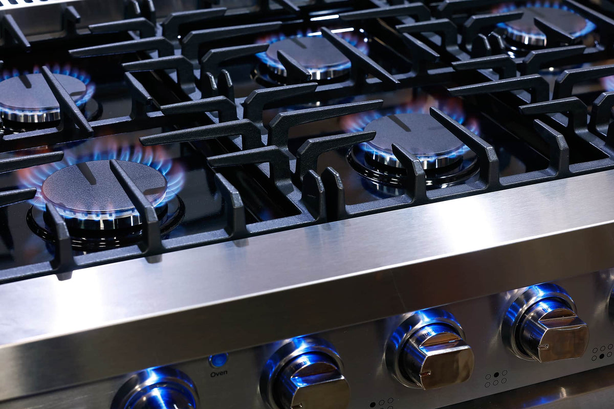 Stainless steel gas range cooktop with blue flame burners and control knobs