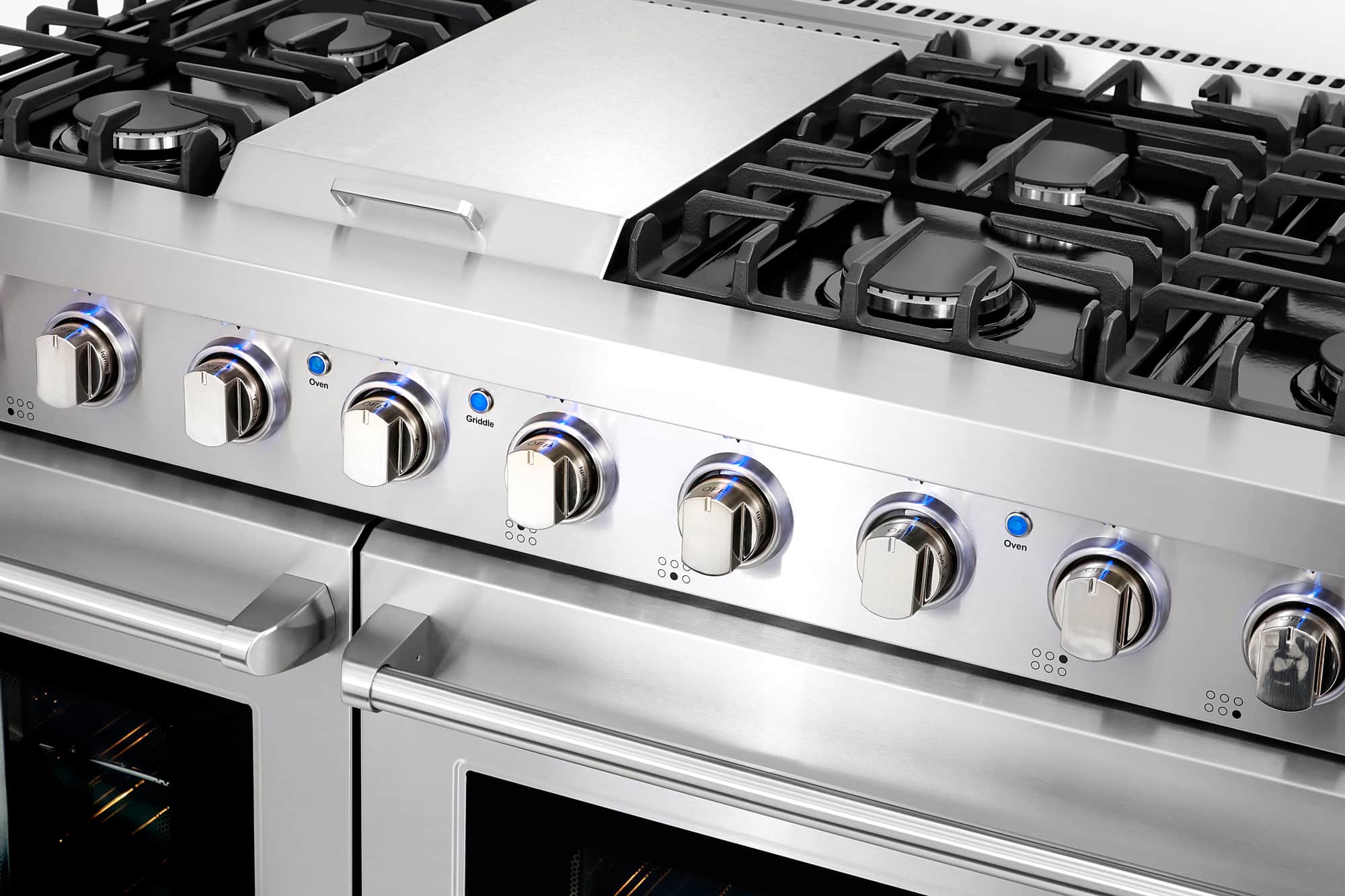 Stainless steel gas range control panel with round knobs and centered griddle rail
