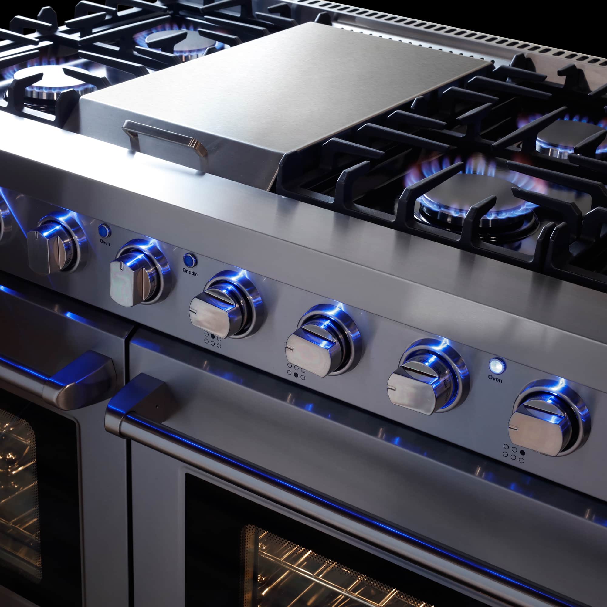 Stainless steel gas range with illuminated burner flames and row of control knobs