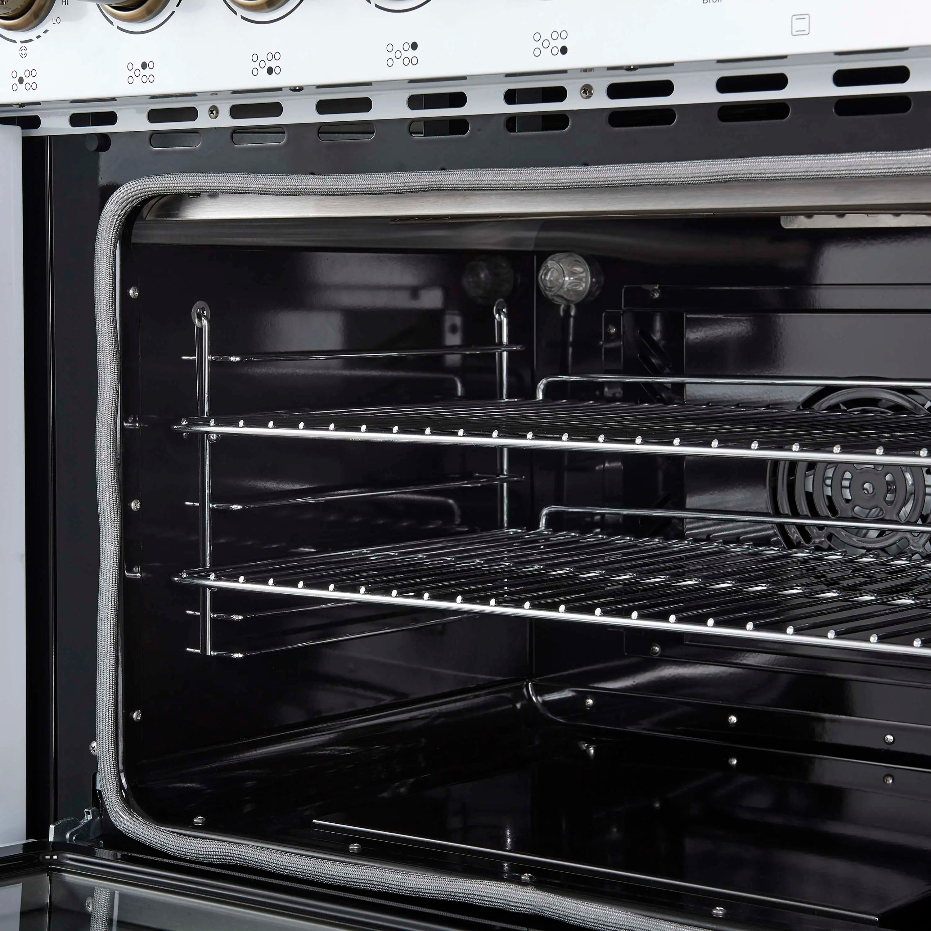 Electric oven interior with wire rack shelves and fan area