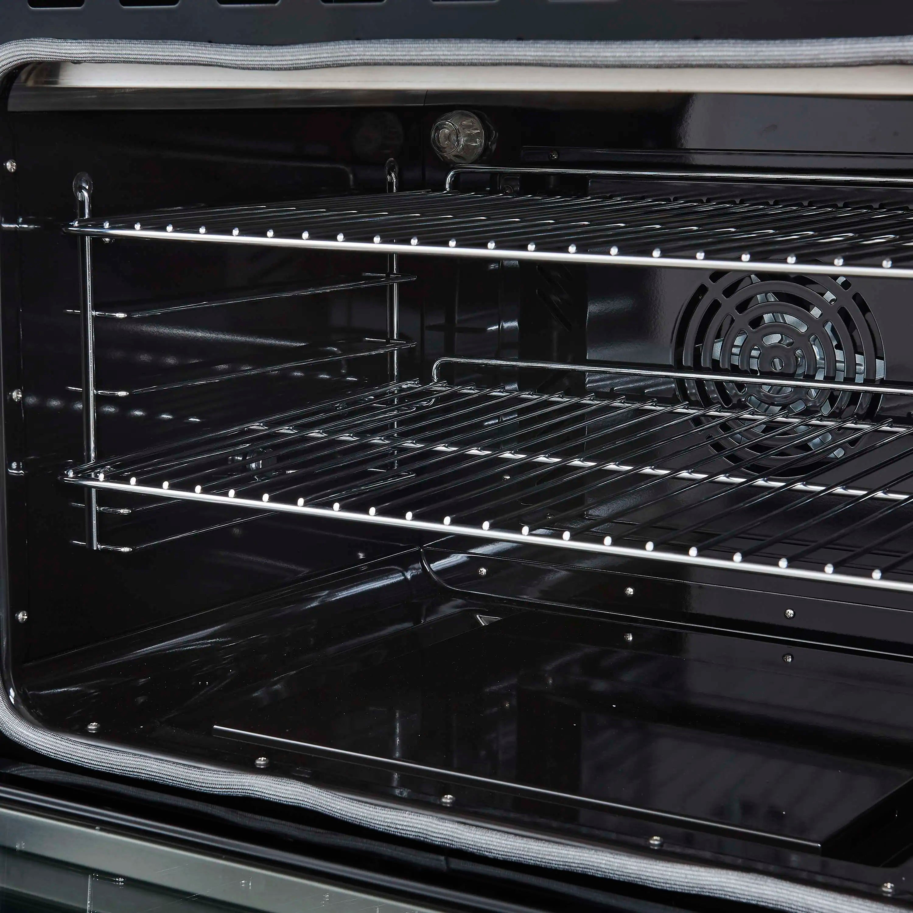 Black electric oven cavity with chrome racks and wire heating elements