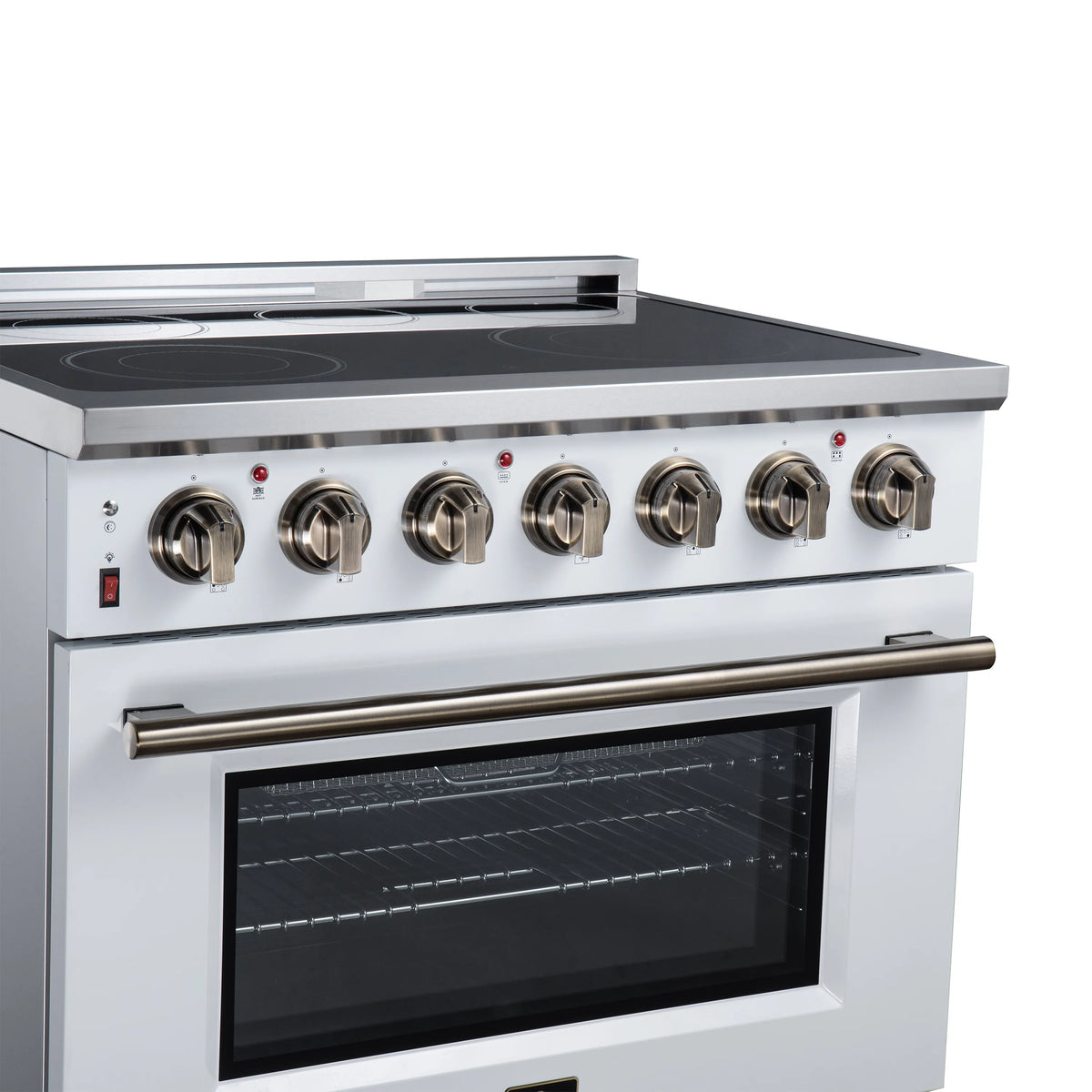 Black glass cooktop with radiant elements and brass-colored knobs above white oven door