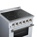 White electric range cooktop with four dark radiant burners and brass-finish control knobs