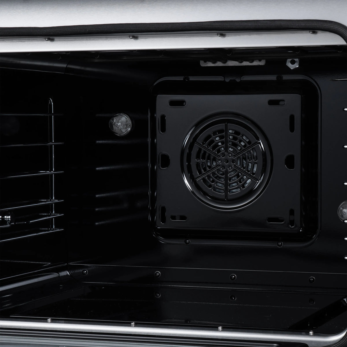 Black electric oven interior featuring round convection fan vent and side heating bars