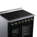 Black electric range cooktop with radiant burner circles and brass control knobs