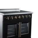 Black electric range control panel with gold knobs above French-door oven doors