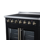 Black electric range front view with gold burner knobs and French-door oven doors