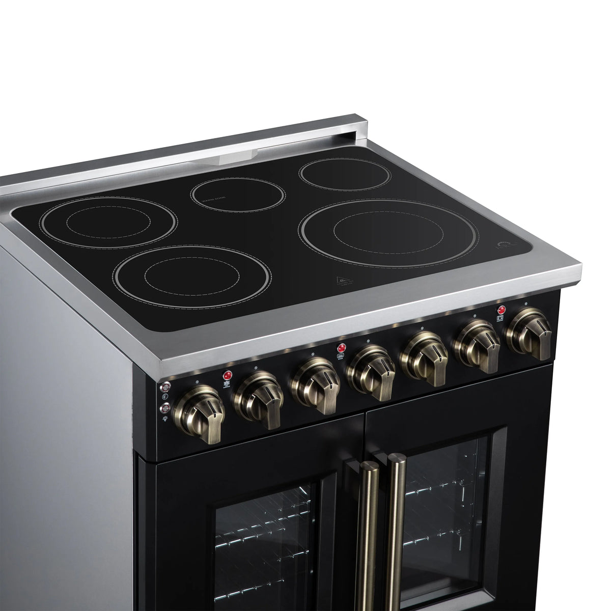 Black radiant cooktop with four burner circles and brass control knobs