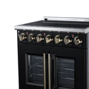 Stainless and black electric range top with brass knobs and double oven doors