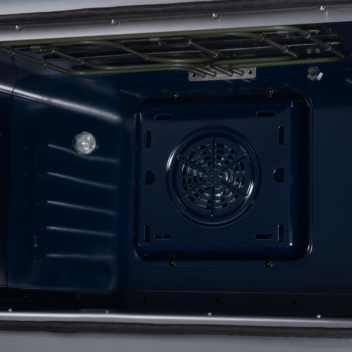 Black electric range oven interior panel with round fan vent near the back