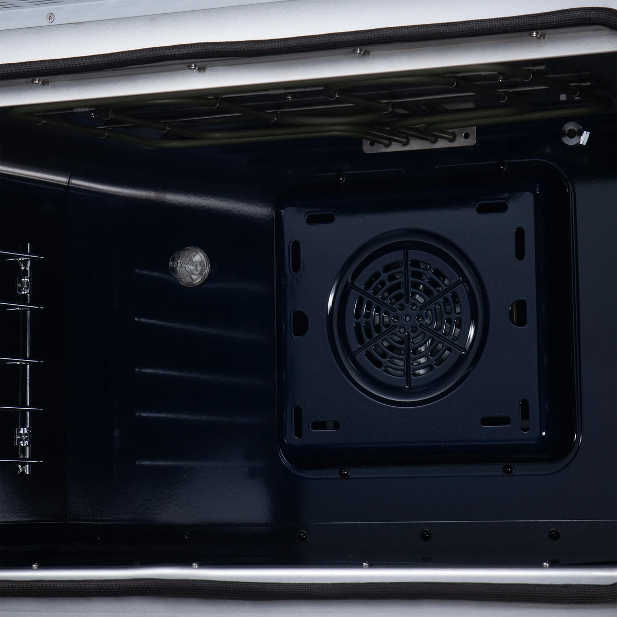 Convection oven interior with circular rear fan vent and oven heating components