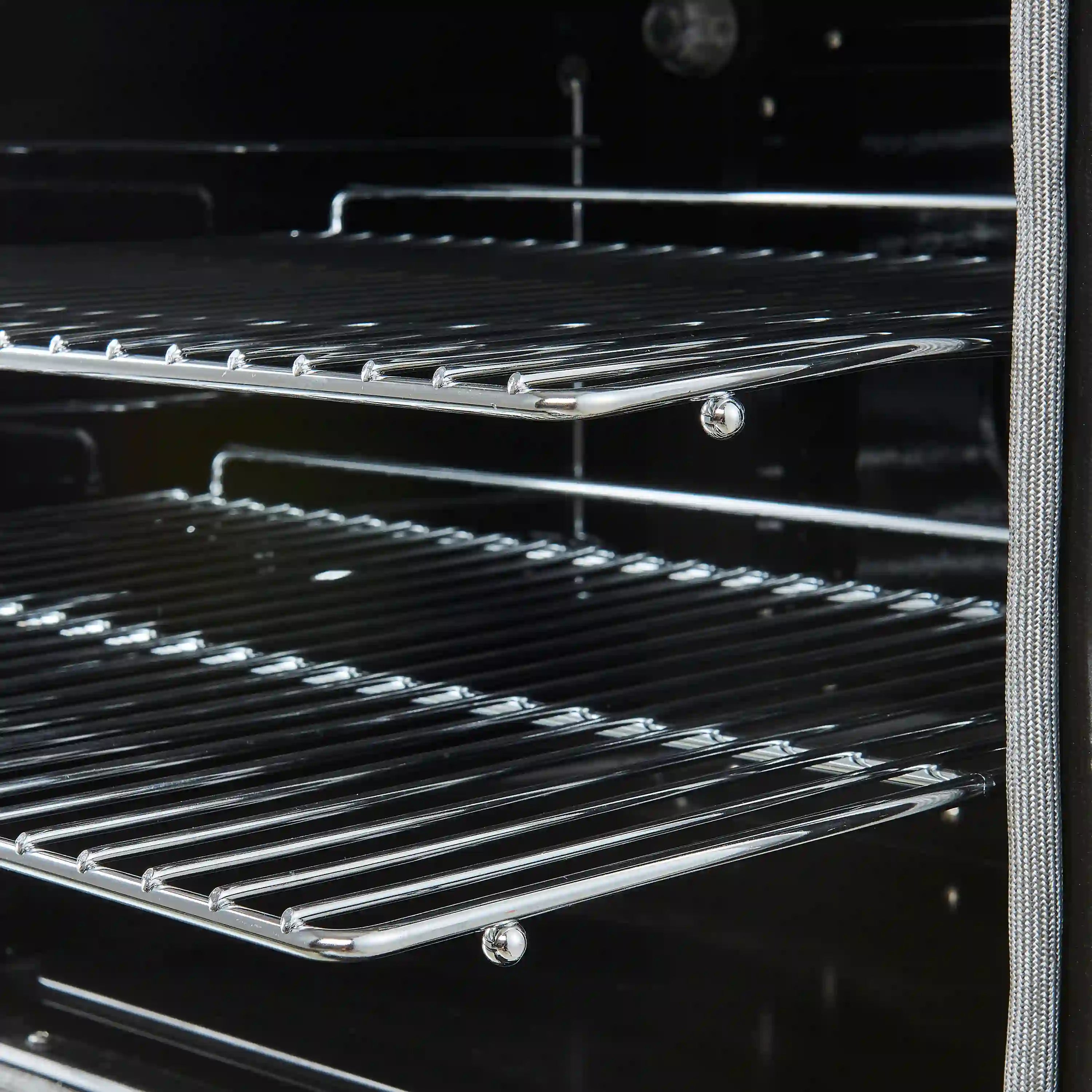 Electric range oven racks with chrome rails inside a black oven cavity