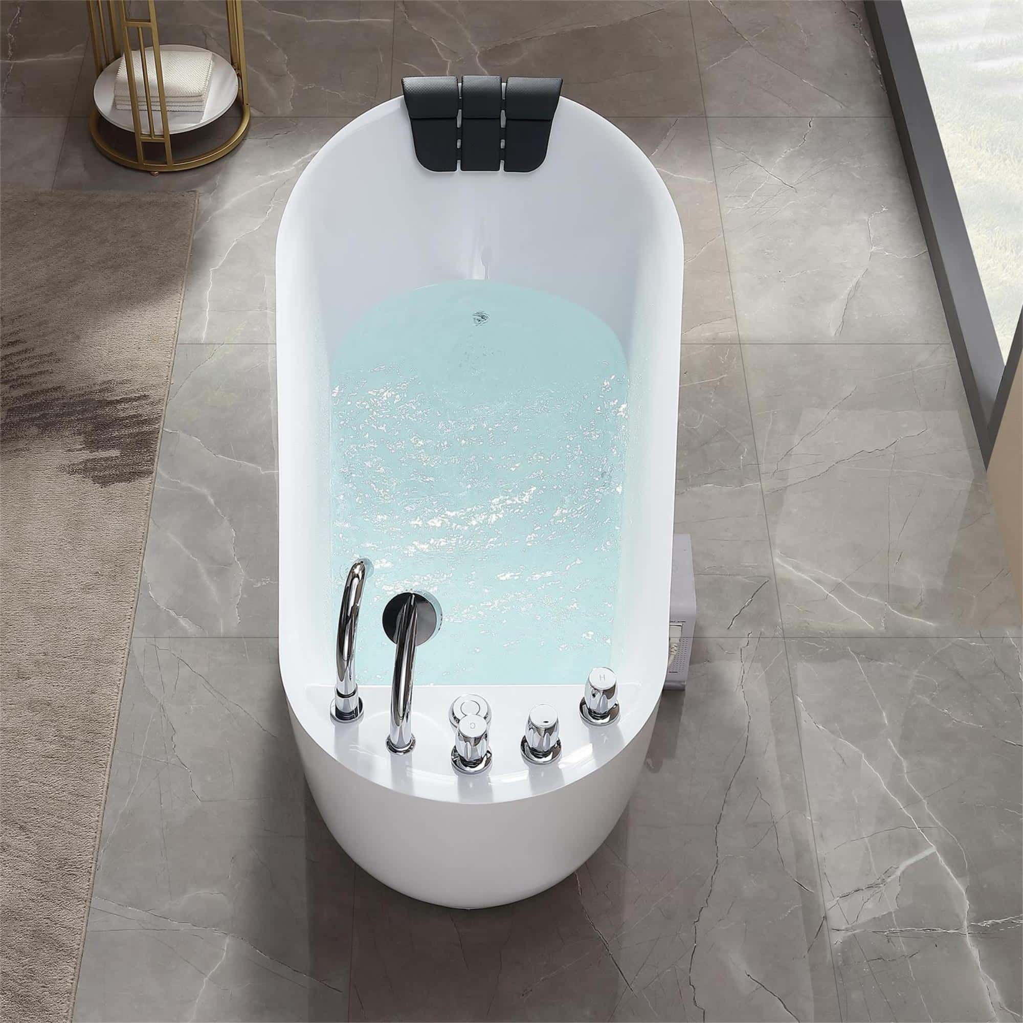 Freestanding white acrylic whirlpool bathtub with chrome faucets and black headrest