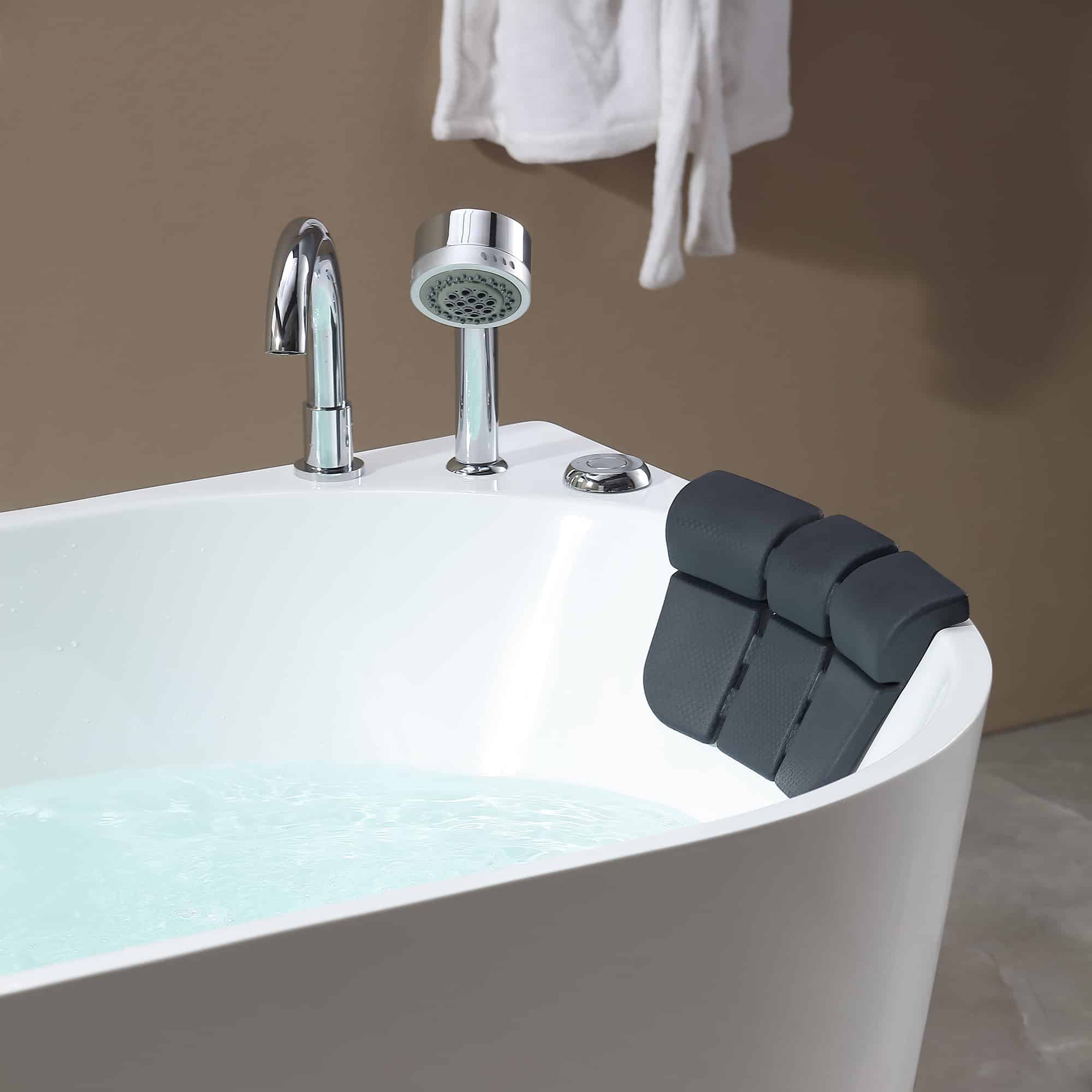 White whirlpool bathtub rim with chrome faucet and mounted black adjustable headrest