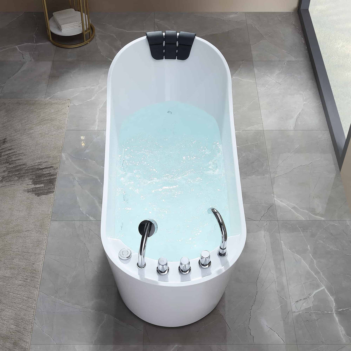 White freestanding acrylic whirlpool bathtub showing chrome controls and light blue basin.
