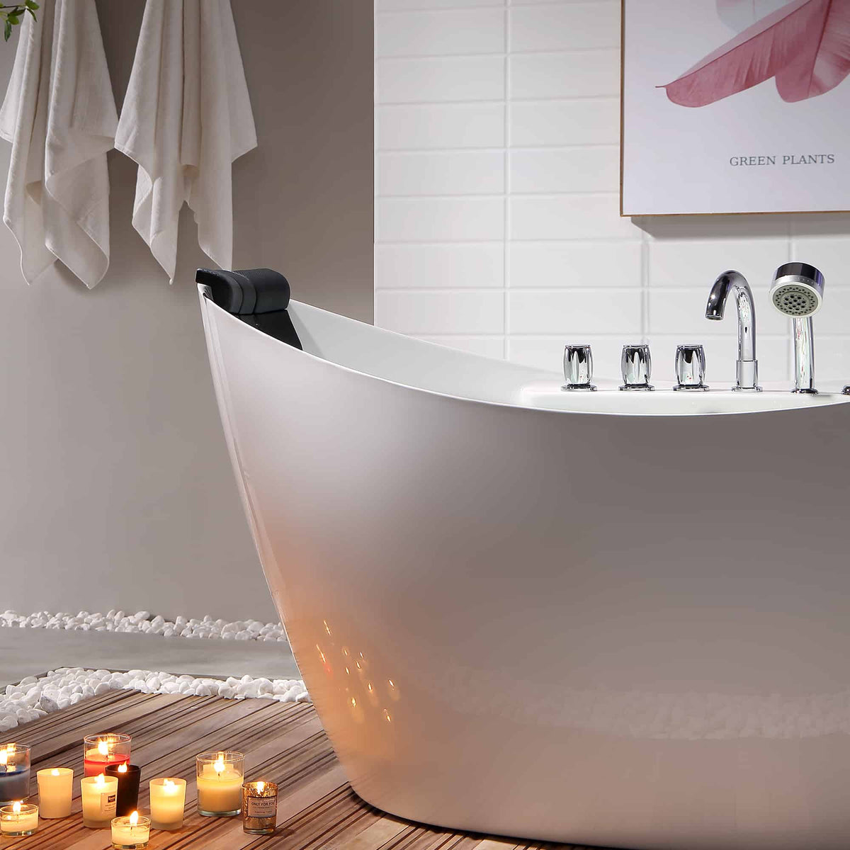 White freestanding acrylic bathtub with chrome faucet and black headrest, candlelit setup.