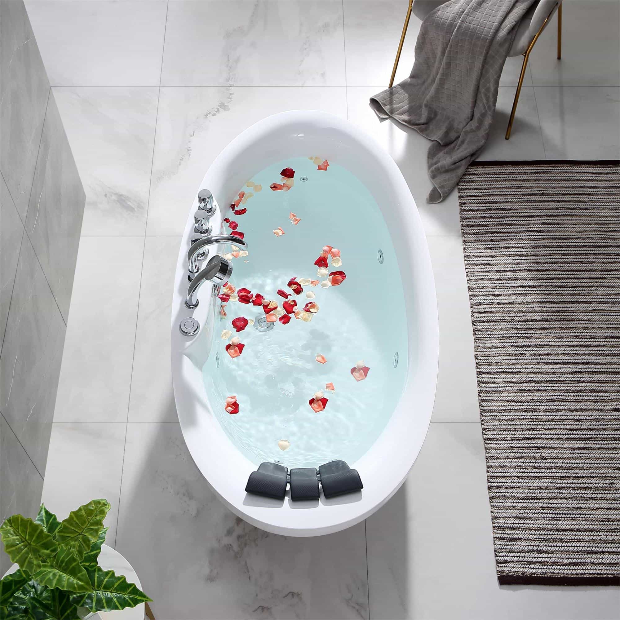 White oval whirlpool bathtub filled with water and scattered rose petals