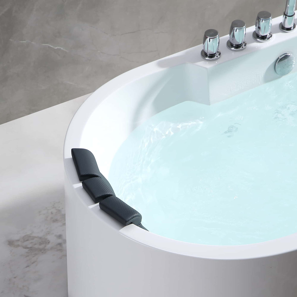 Close-up side view of white oval whirlpool bathtub rim, dark headrest, and jets