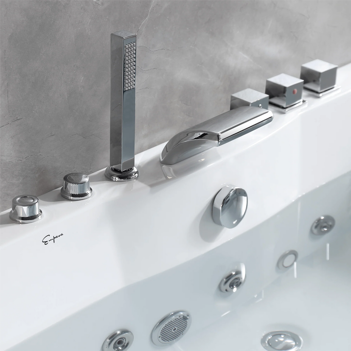 Chrome faucet and control knobs on the rim of a white whirlpool bathtub