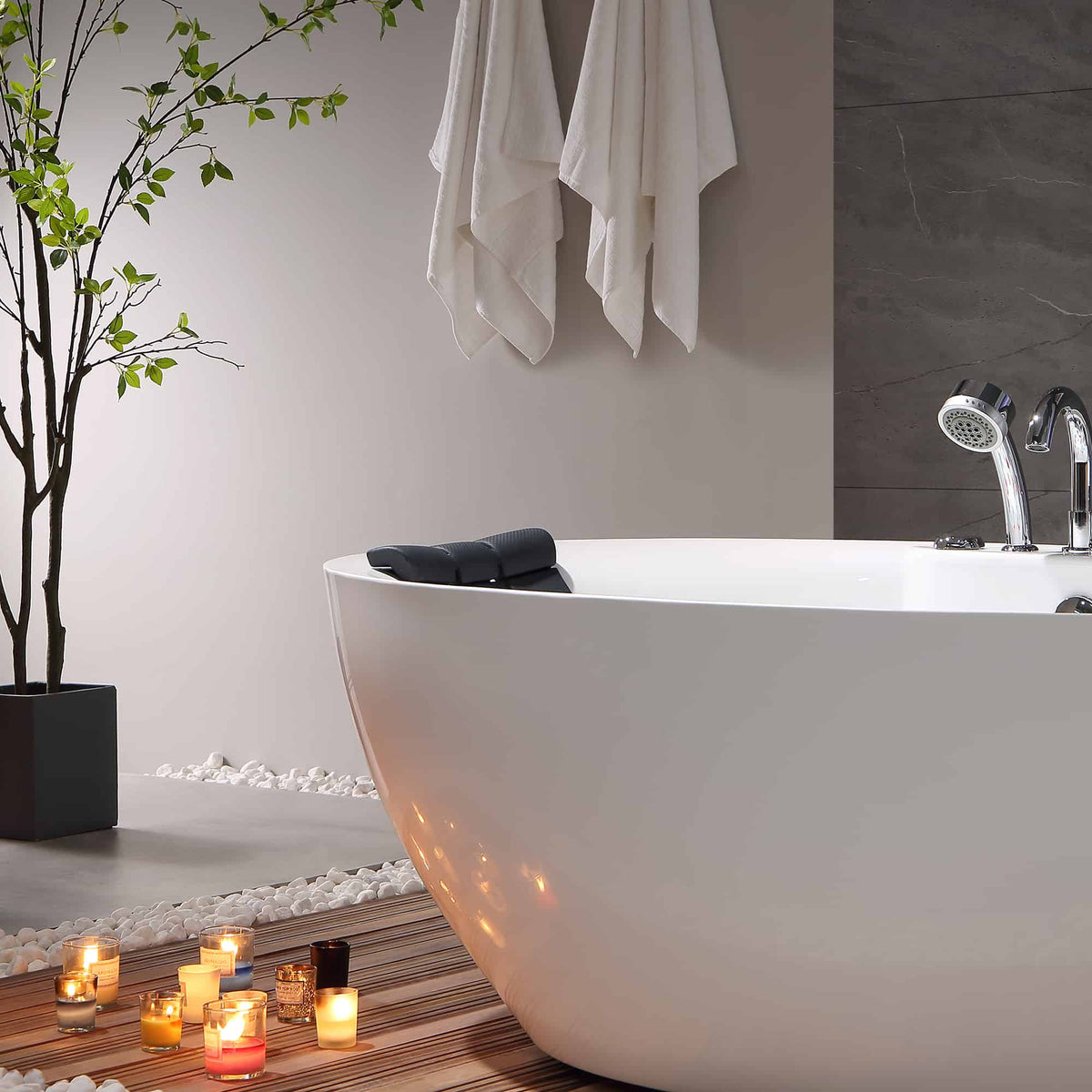 White freestanding acrylic whirlpool bathtub with chrome faucet and black headrest