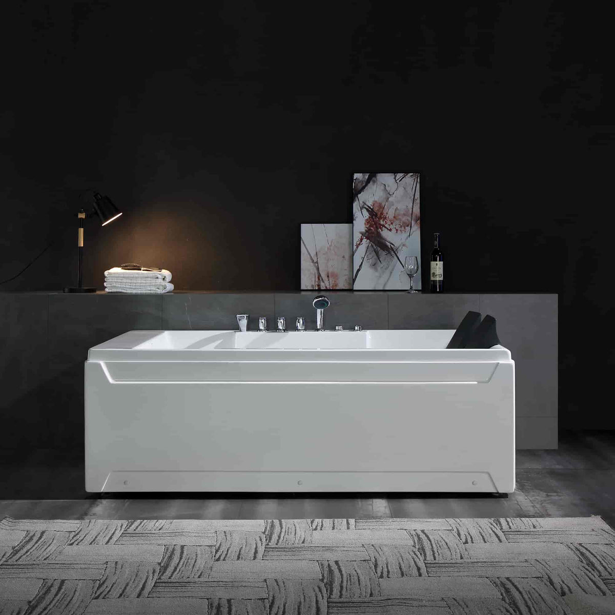 White rectangular bathtub with chrome faucet fixtures and two black headrests