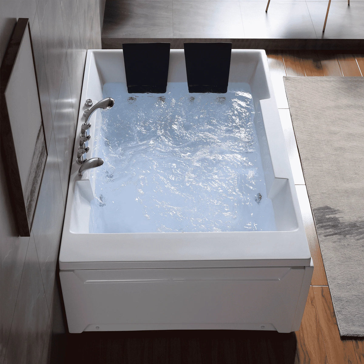 White whirlpool bathtub with chrome faucet, two black headrests, and filled jets
