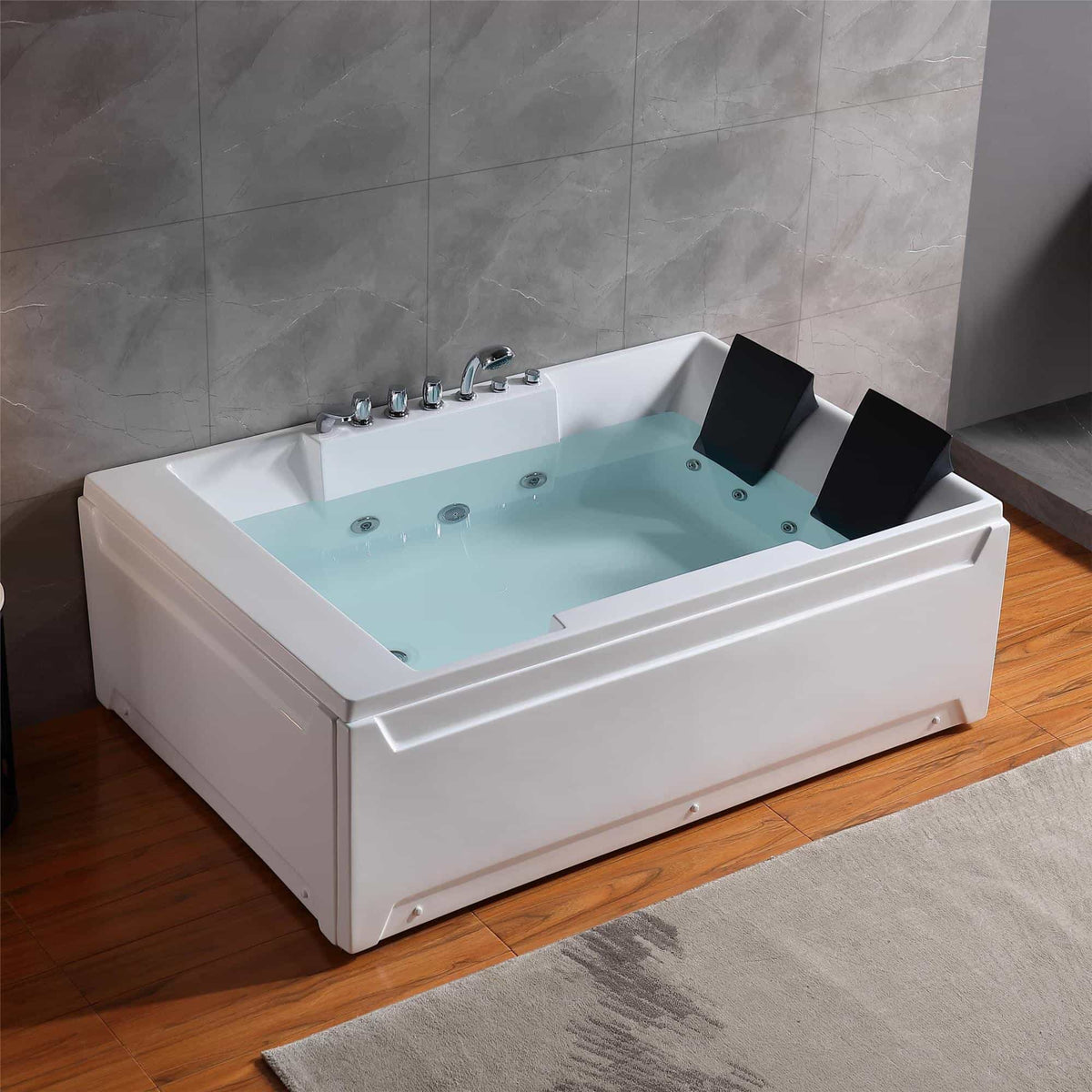 White rectangular whirlpool bathtub with chrome faucet, two black headrests, and jets