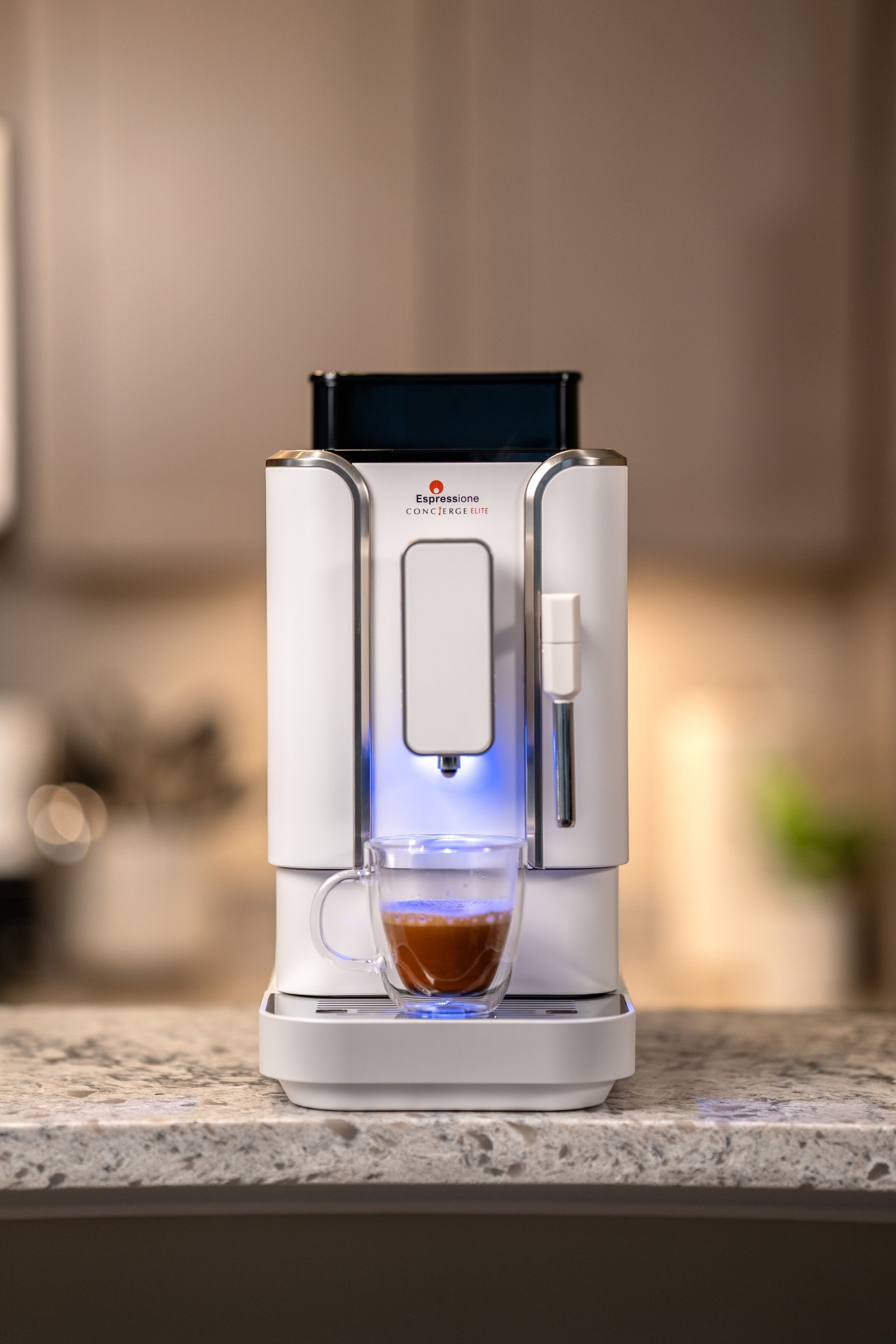 Diamond white fully automatic bean-to-cup espresso machine on countertop with glass cup
