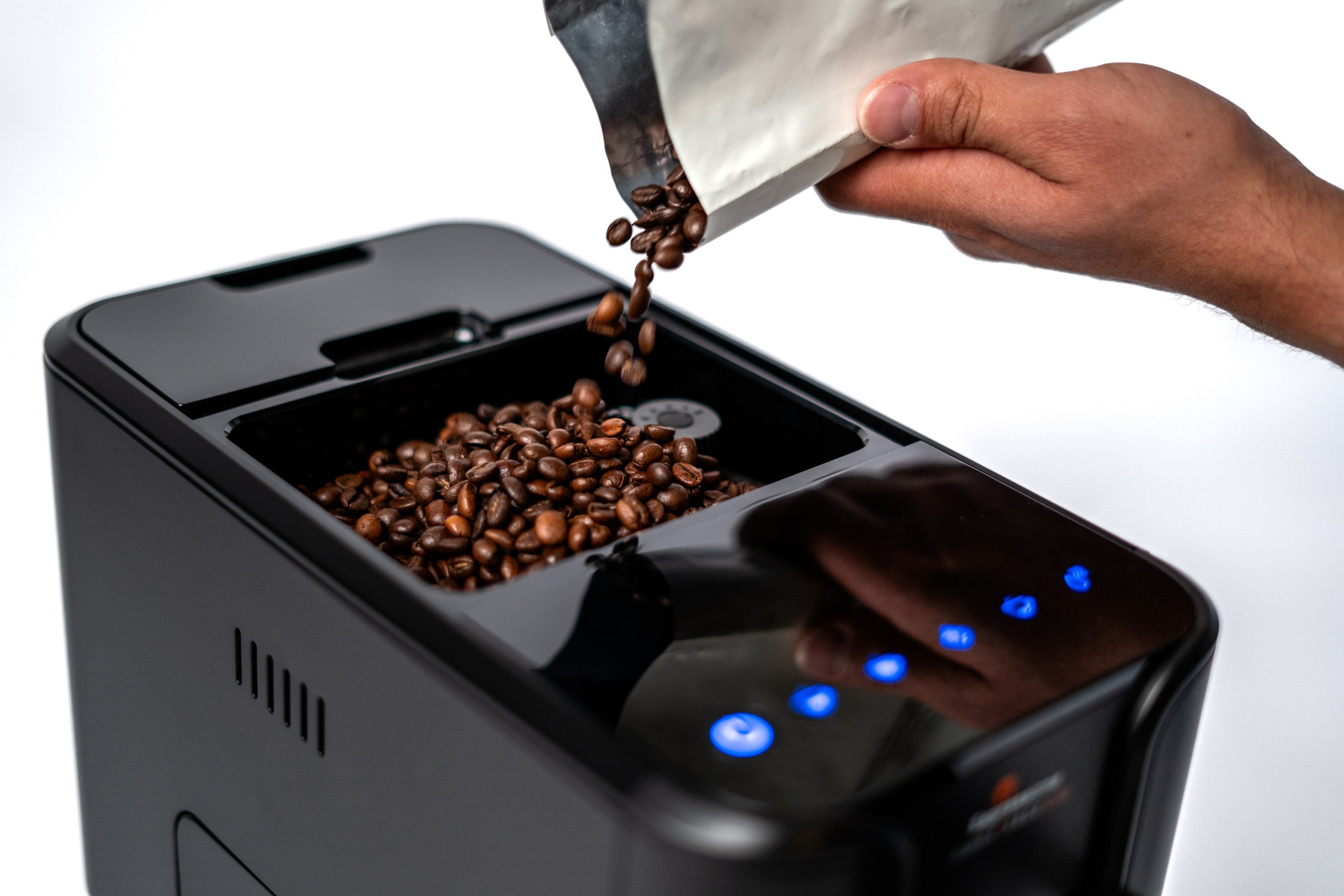 Coffee beans being poured into black bean hopper