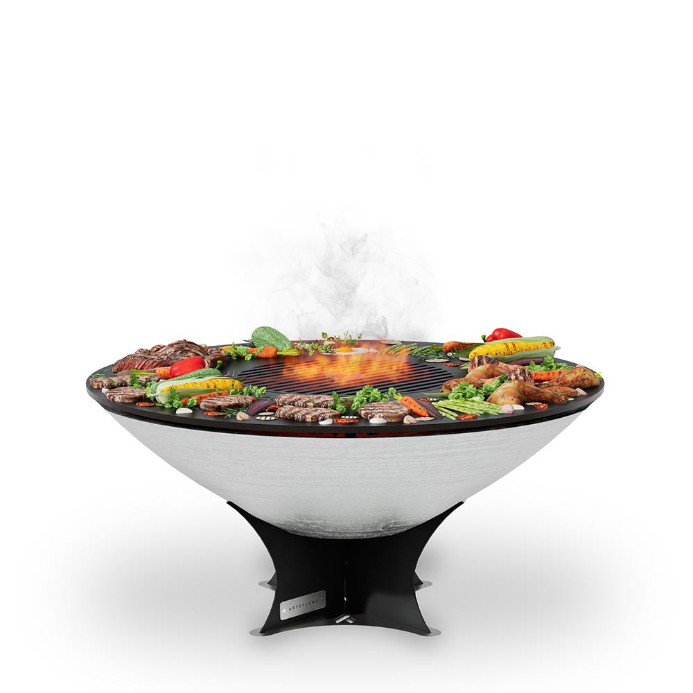 Stainless steel fire pit with cooktop, low stand, and visible flames over grill