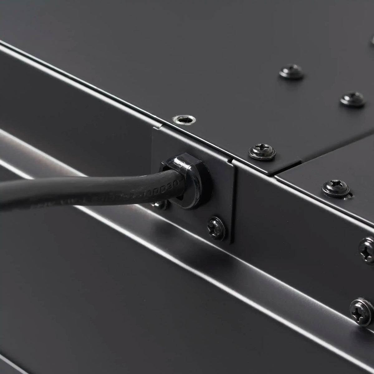 Black metal fireplace control edge with push button and screws, close-up