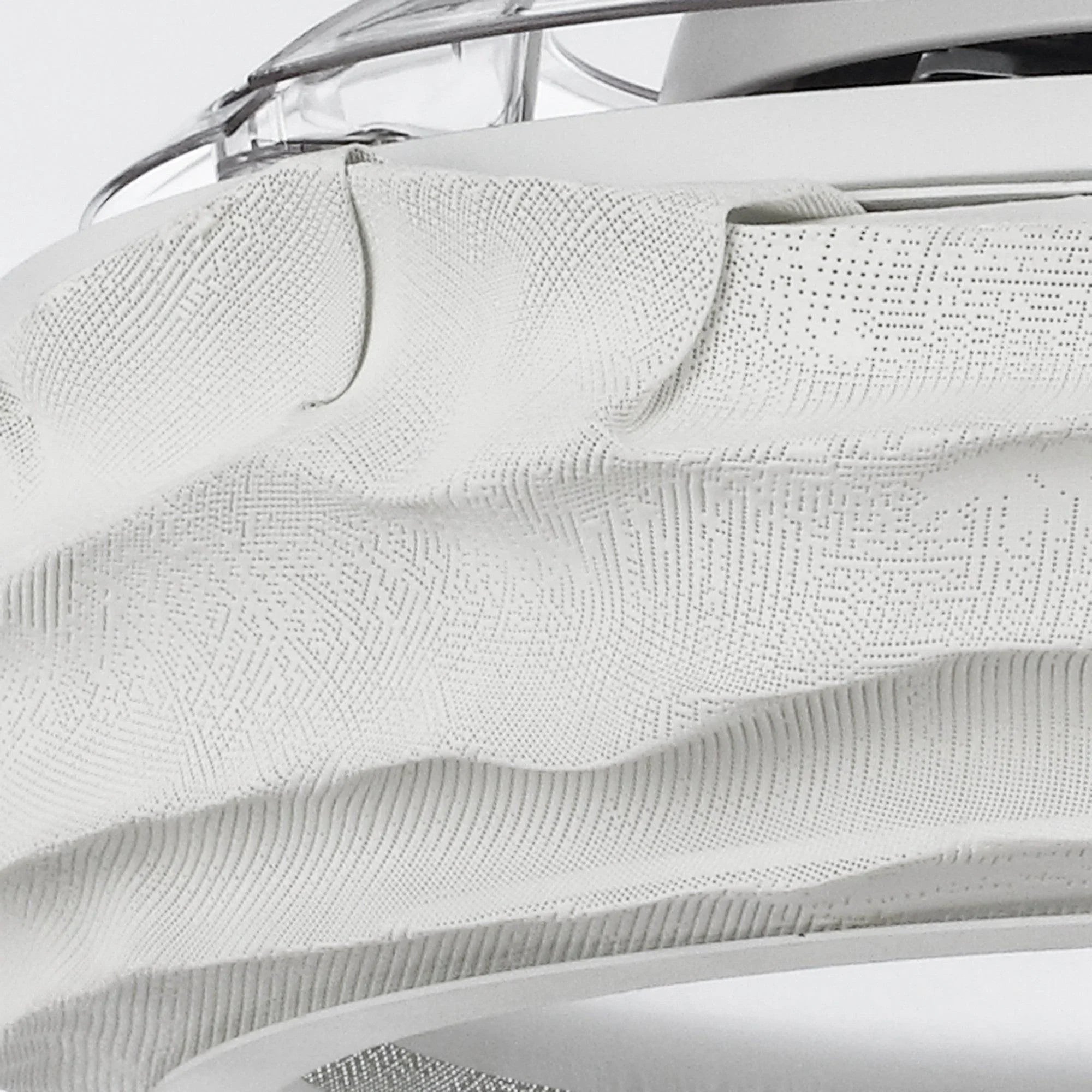 Close-up of textured white fan blade with fine pattern under the LED-lit ring