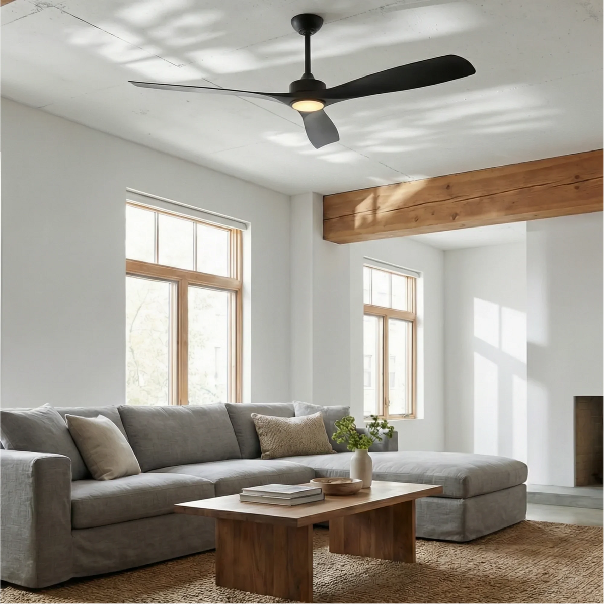 Ceiling fan with LED light, black motor and black blades over a modern living room couch