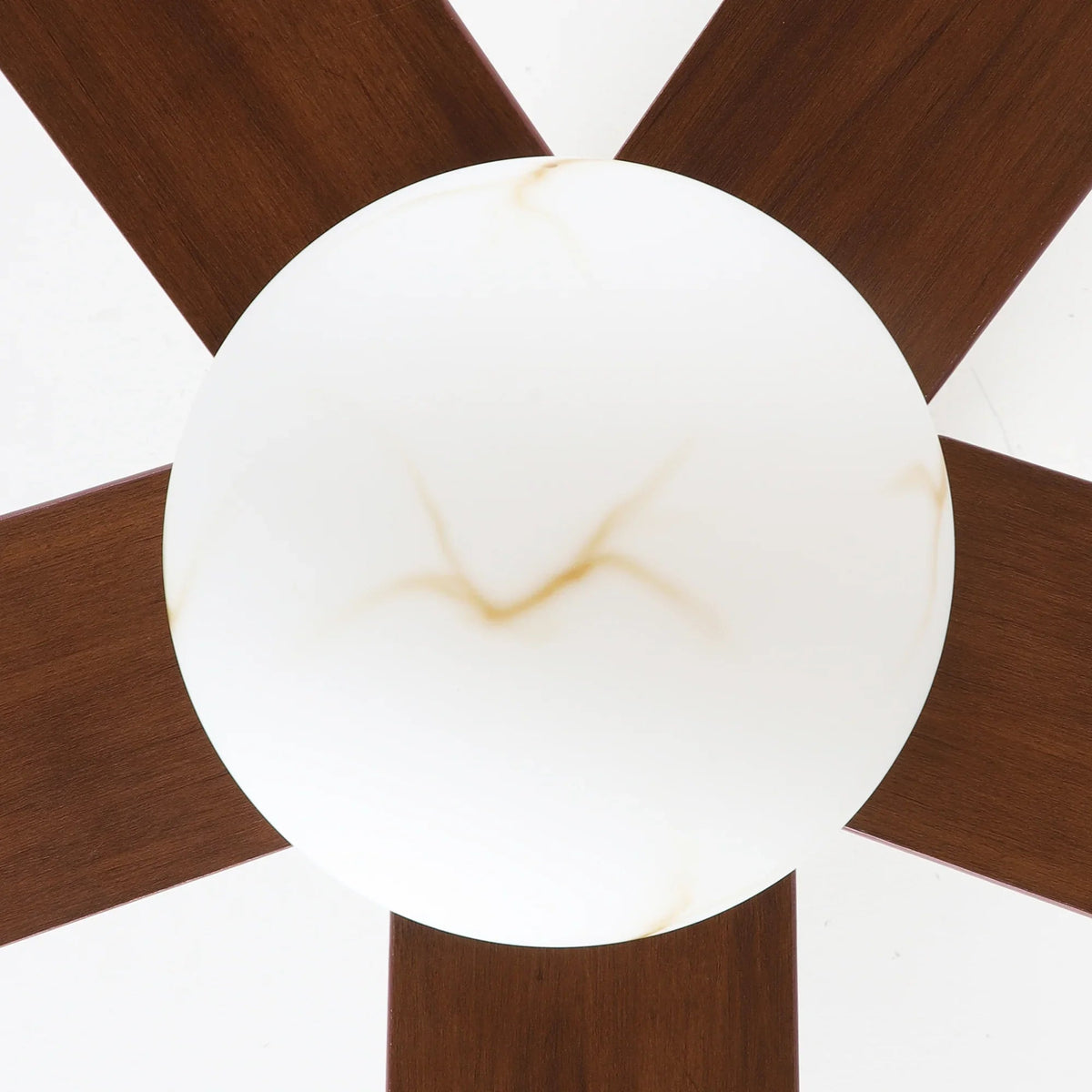Close-up of frosted globe LED light on a golden ceiling fan with dark blades