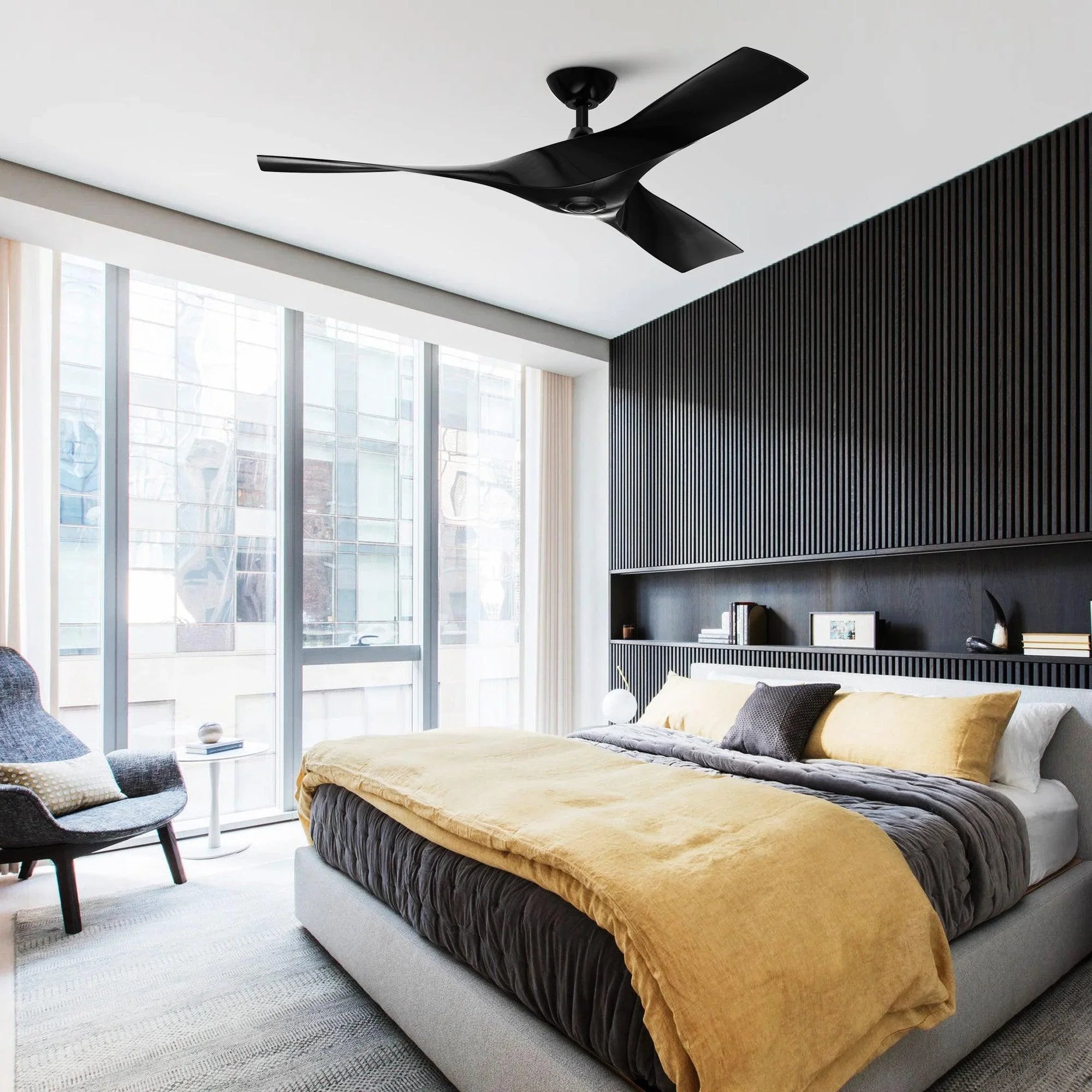 Black reversible ceiling fan in modern bedroom with downrod mount and three blades