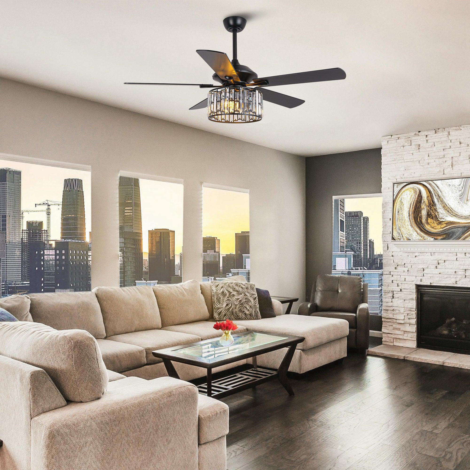 Ceiling fan with dark blades and crystal drum light centered over a sofa seating area.