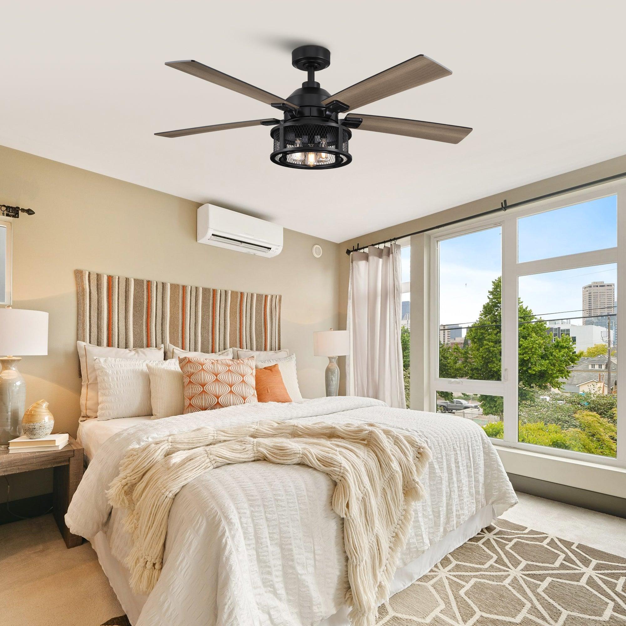 Black ceiling fan with five wood blades and lit light fixture above a bedroom