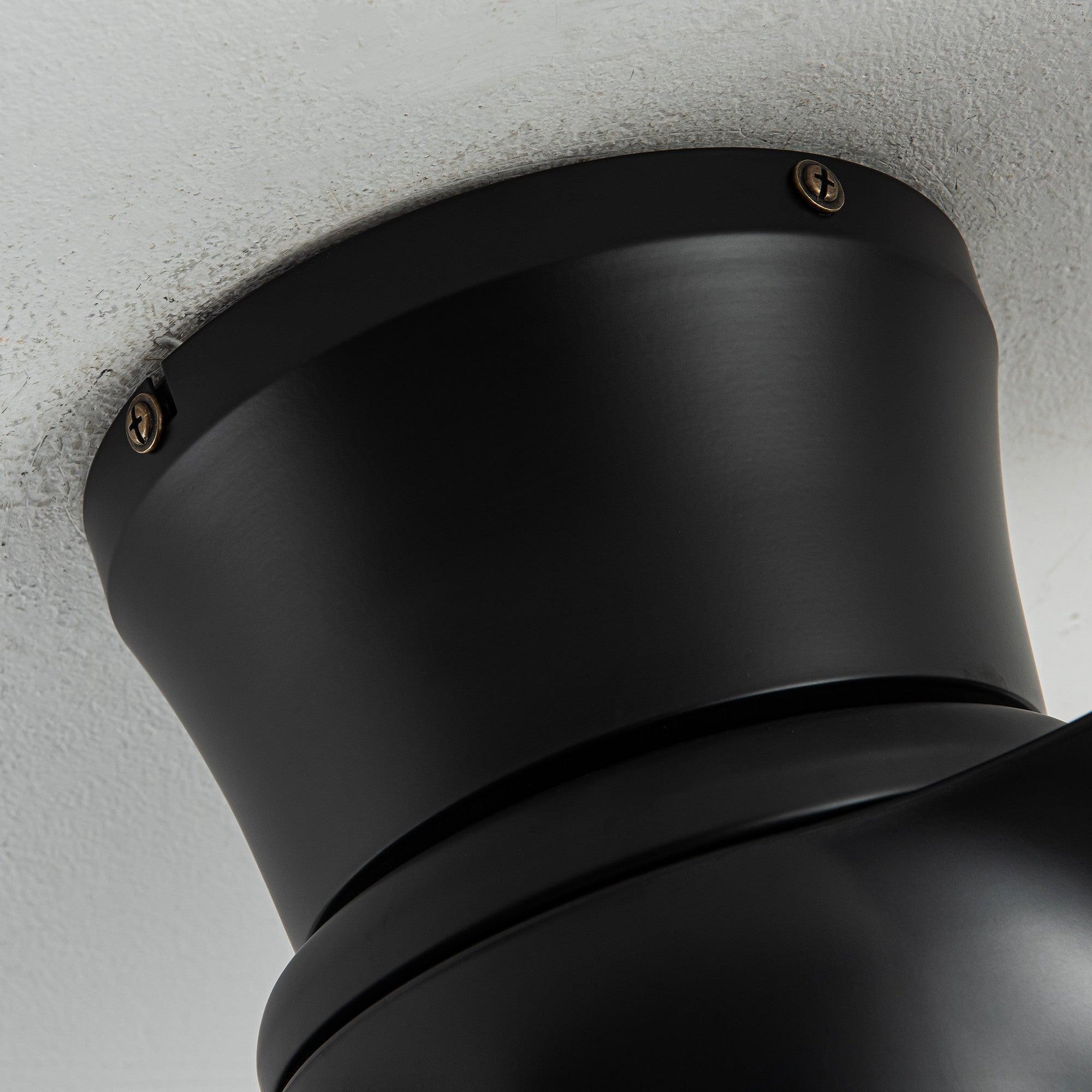 Close-up of black ceiling fan canopy on the ceiling with visible mounting screws