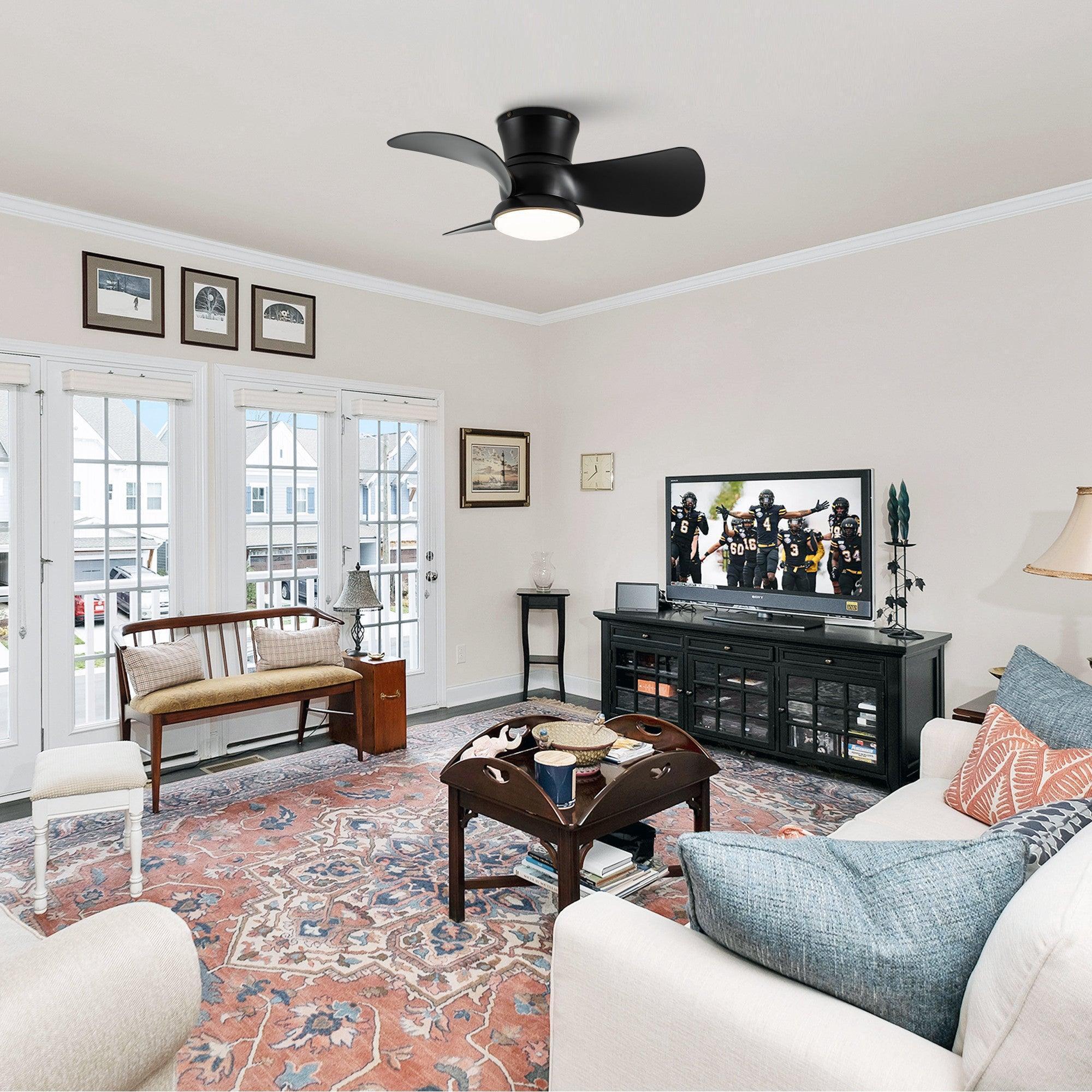 Black flush mount ceiling fan with round white LED light in a living room setting