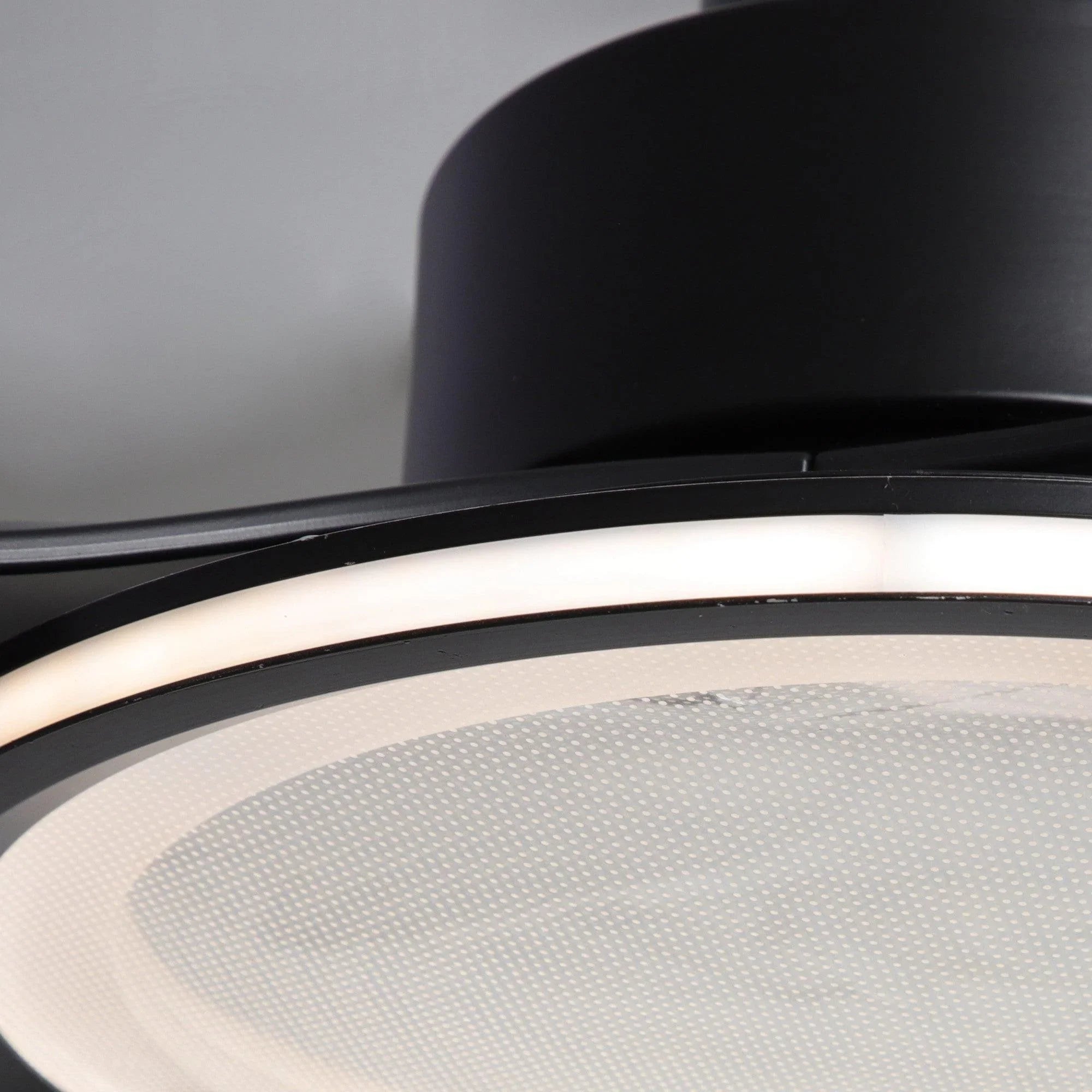 Black ceiling fan light with circular frosted diffuser and trim ring.