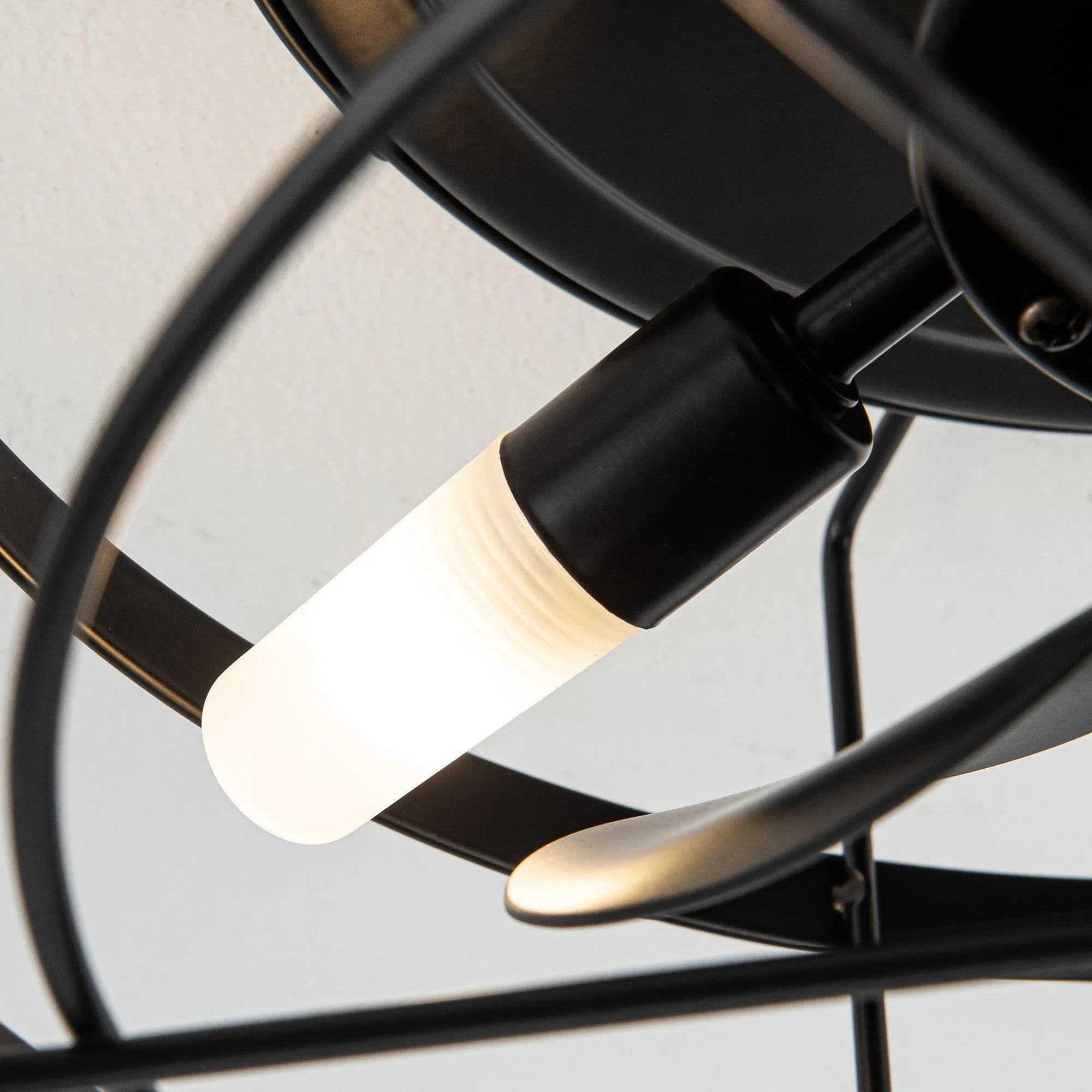 Black flush-mount ceiling fan with integrated light, exposed socket detail and blades