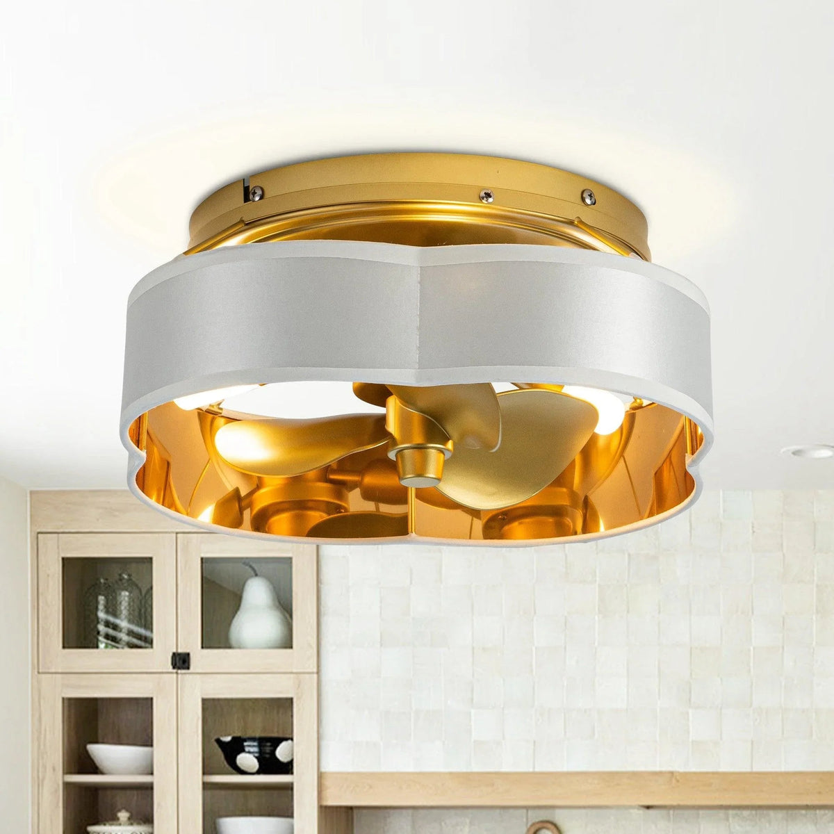 Golden flush mount ceiling fan with light beneath a gold ring, blades visible