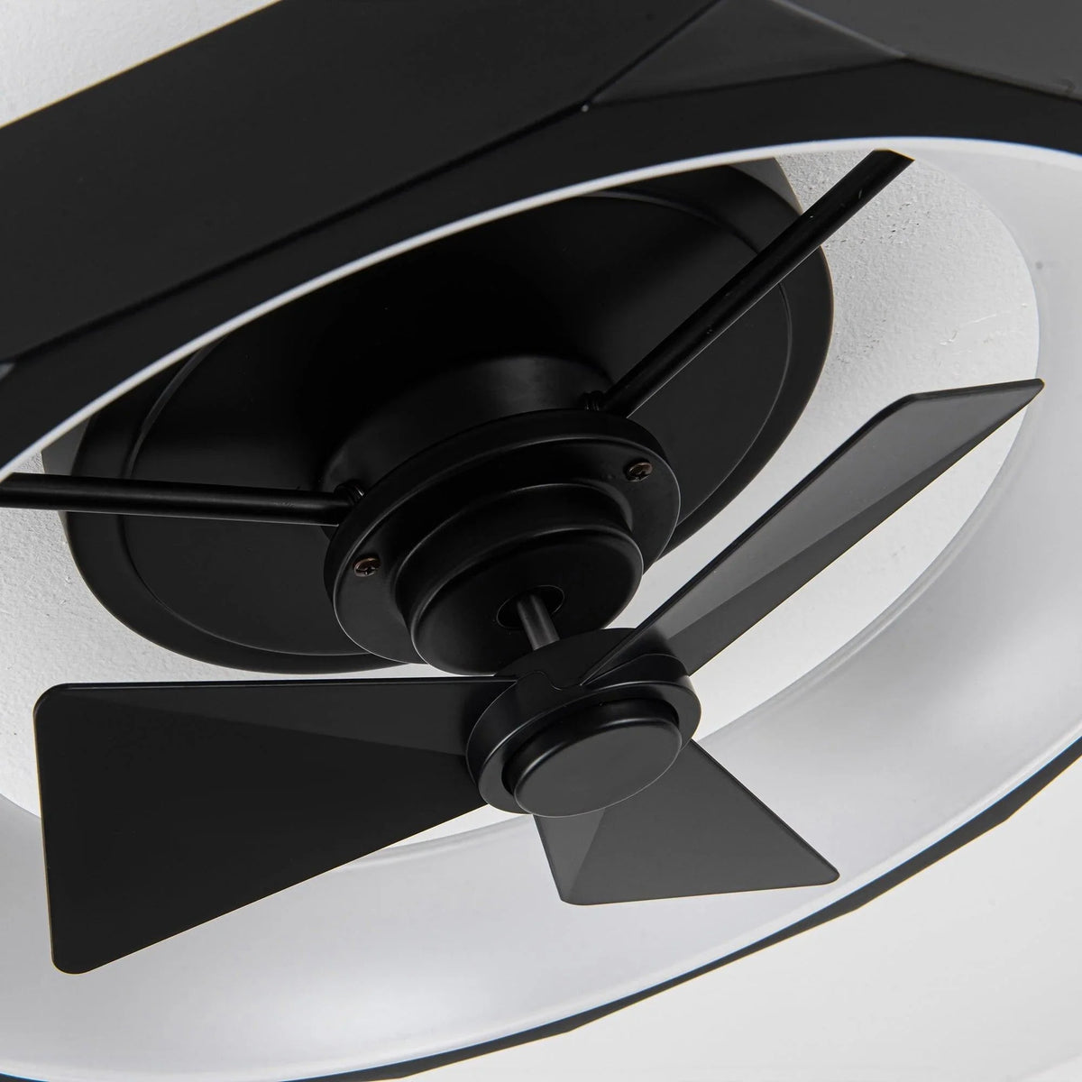 Black flush mount ceiling fan close-up of motor hub and three blades