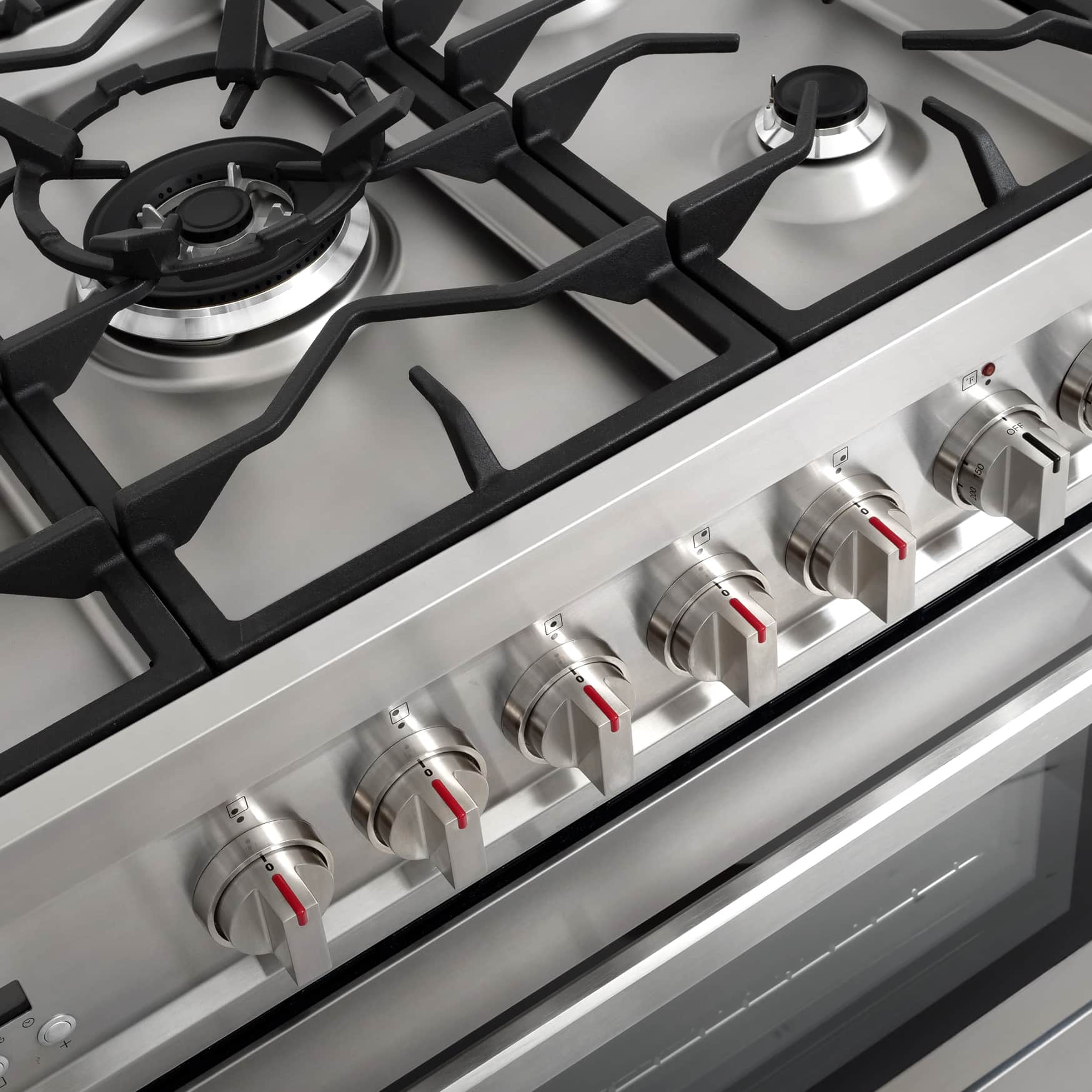 Stainless steel cooktop control area with burner grates and front knob row