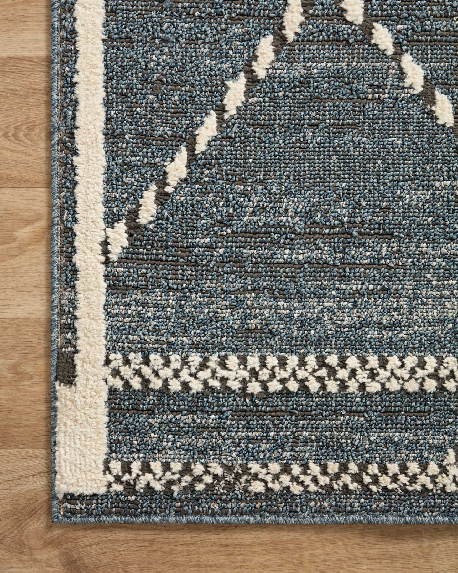 Charcoal and denim-blue area rug with cream corner border and diamond motifs