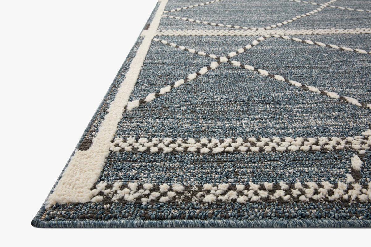 Transitional area rug with blue-gray ground and cream geometric border, textured loop pile.